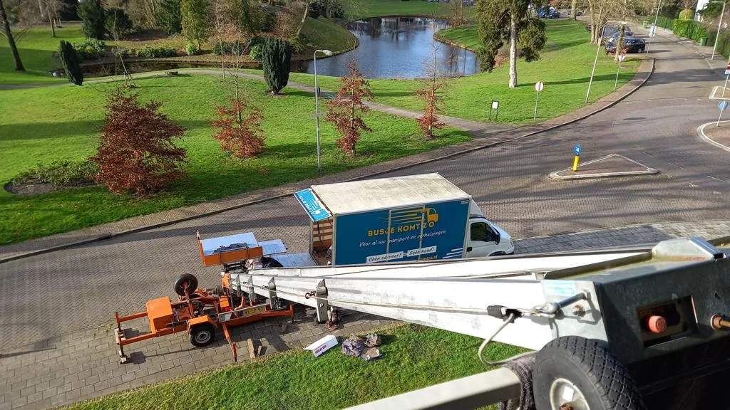 Busje komt zo verhuiswagen en verhuislift tijdens een verhuizing
